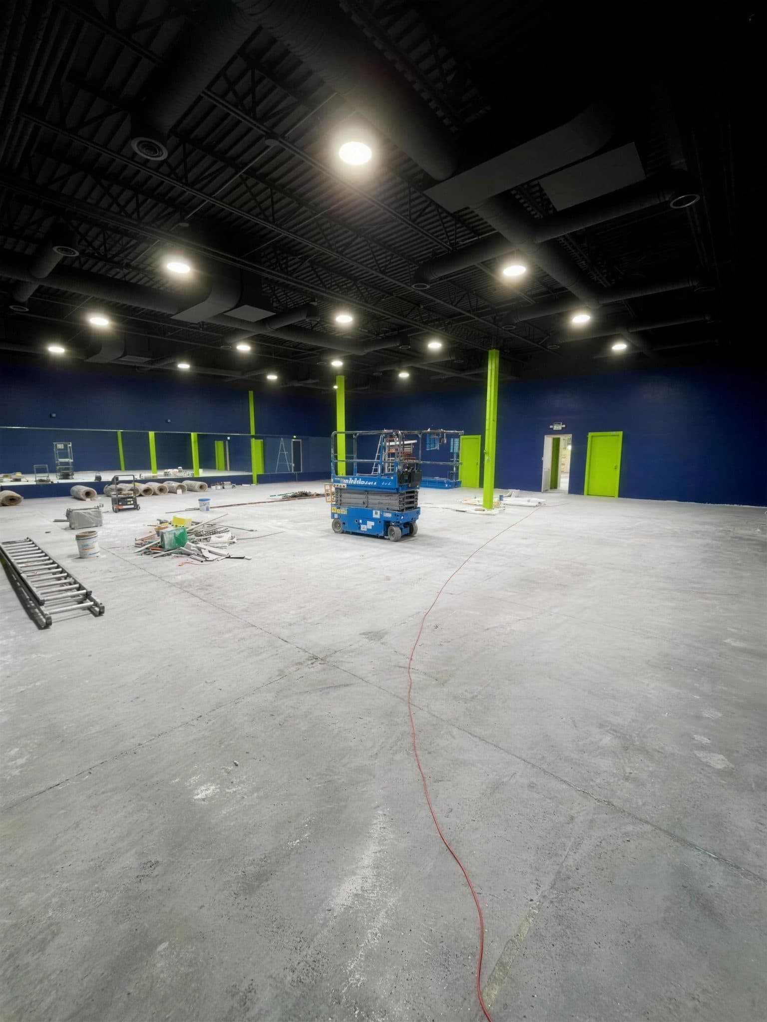 Pulze gym in Pharr after painting, with navy walls, lime green columns and a black ceiling.