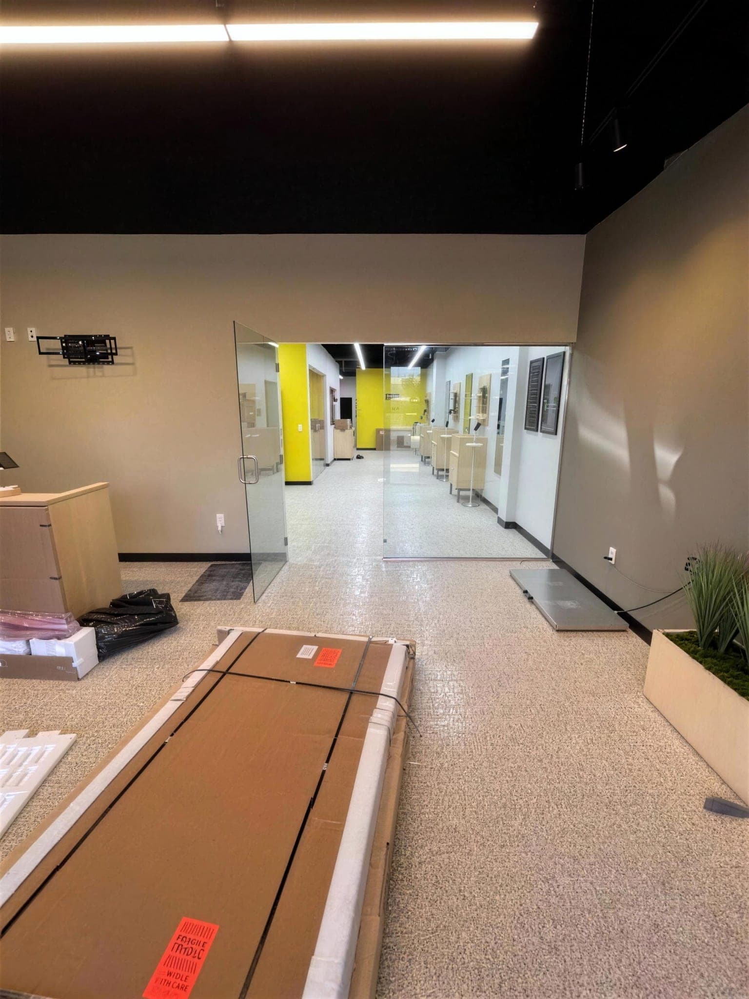 Long hallway with a speckled flake epoxy floor and a yellow accent wall at the far end.